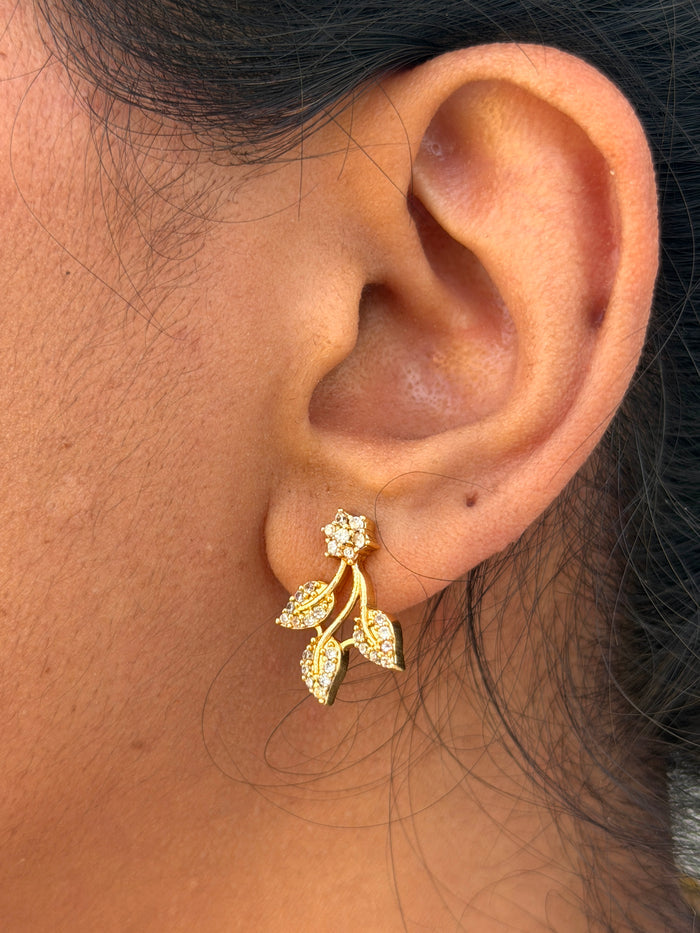 ear wearing a gold earring with leaf design