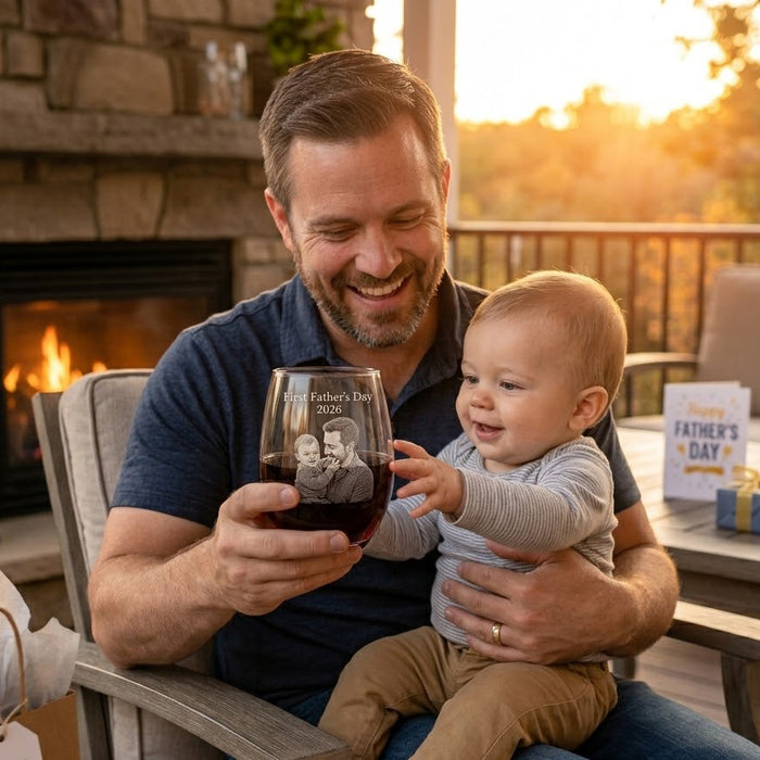 Father holding baby with personalized engraved wine glass, a meaningful custom Father’s Day or new dad gift.