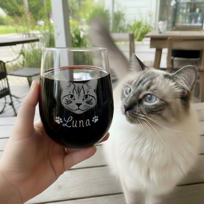 Custom cat portrait wine glass engraved with pet name Luna, shown beside a cat as a personalized pet glass.