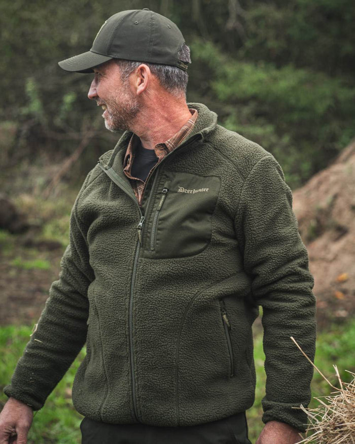 Forest Green coloured Deerhunter Atlas Fleece Jacket on forest background #colour_forest-green