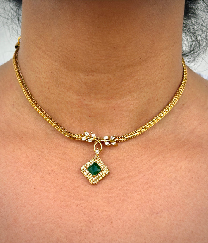 gold earring with green and white stone
