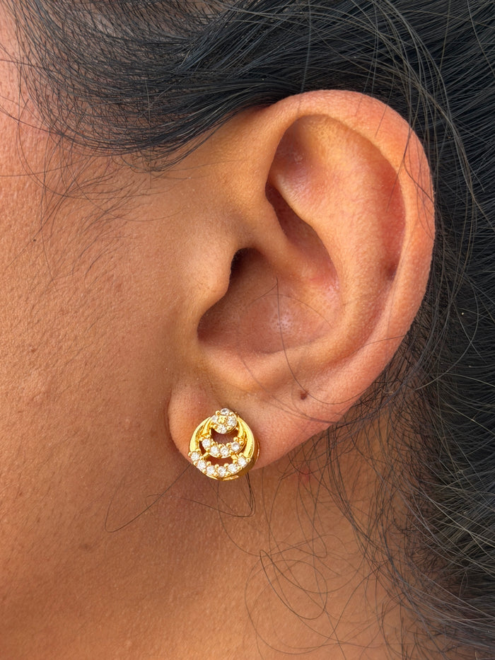 Close-up of an ear wearing a gold earring