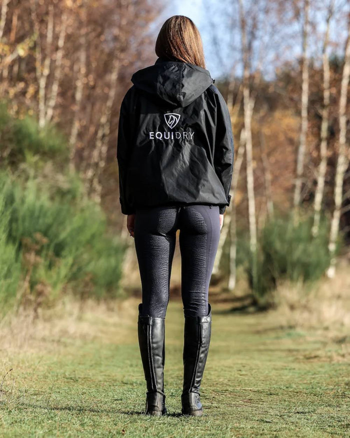 Black coloured Equidry Womens Equimac Shortie With Stowaway Hood on outdoor background #colour_black