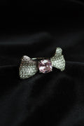 Silver bow-shaped ring with a pink gemstone