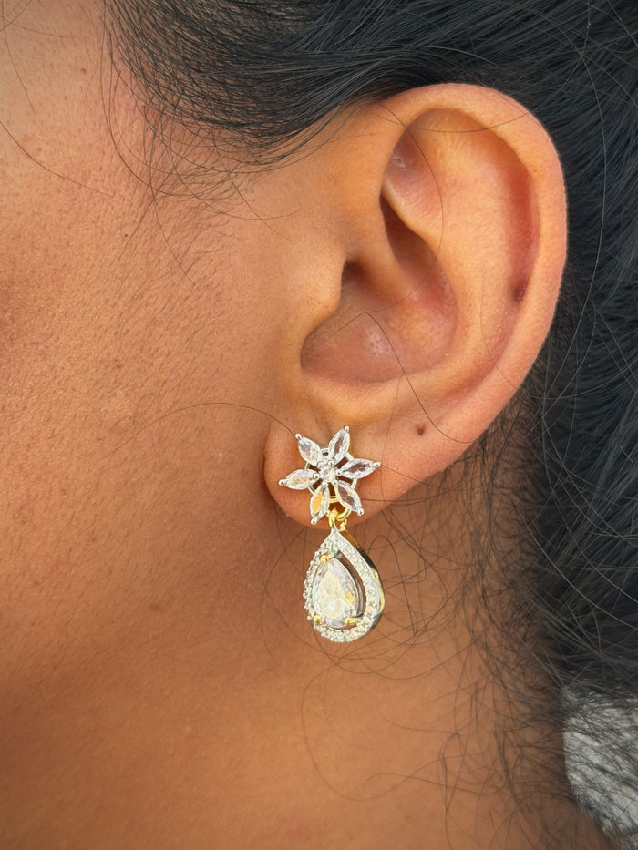 ear wearing a star-shaped earring with a teardrop design.