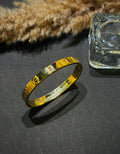 Gold bracelet on a dark surface