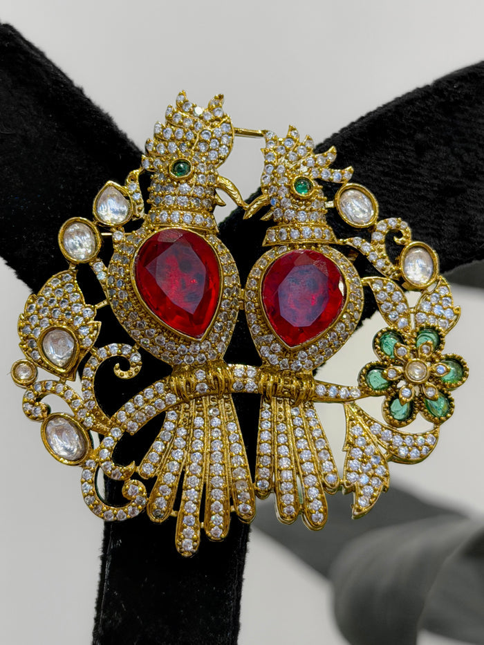 Ornate brooch with red stones