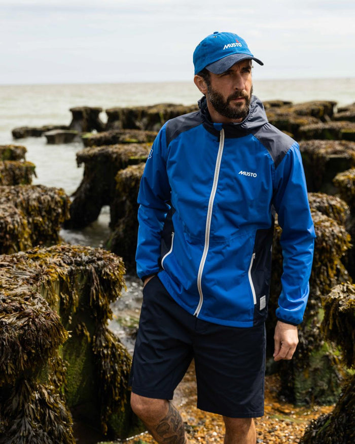 Navy Coloured Musto Mens RIB Fast Dry Shorts On A Coastal Background #colour_navy