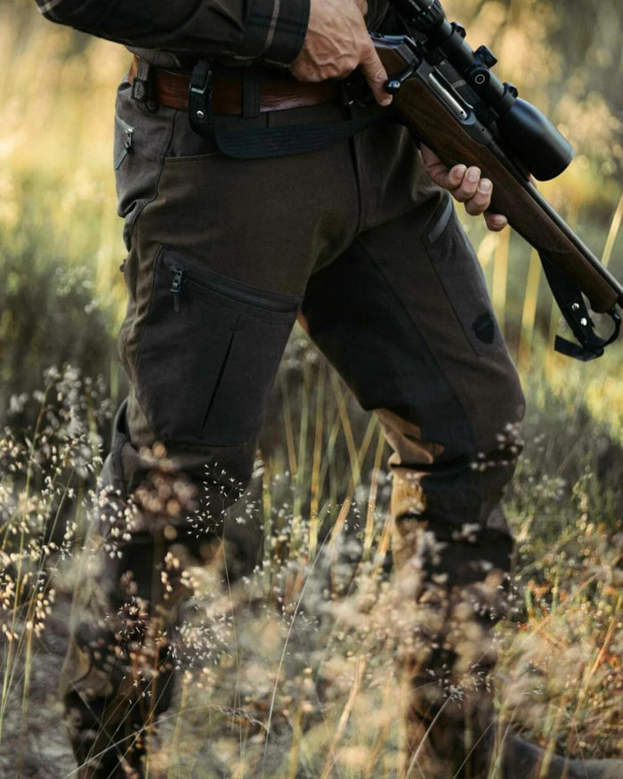 Green coloured Northern Hunting Mens Hakan Bark Waterproof Hunting Trousers on forest background #colour_green