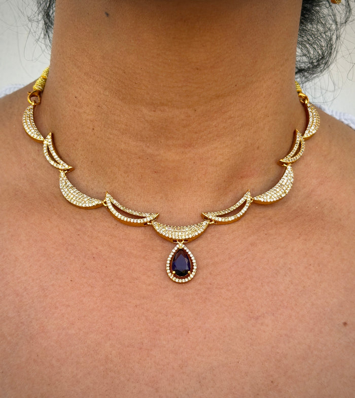 Gold necklace with a central purple gemstone