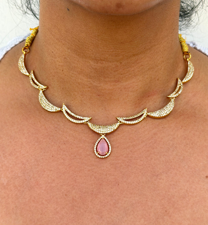Gold necklace with a pink gemstone