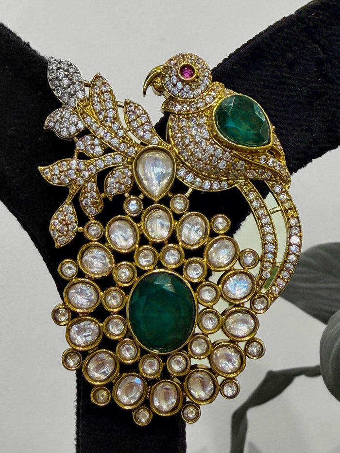 Ornate brooch with parrot design, green stones