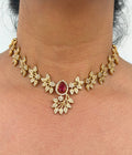 Gold necklace with a red gemstone