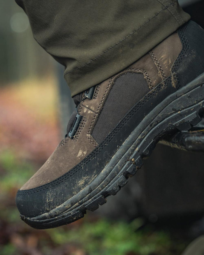 Dark Brown coloured Seeland Enduro Dial Mid Boots on forest background #colour_dark-brown