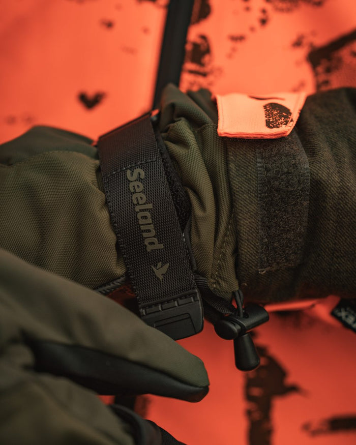 Pine Green coloured Seeland Trigger Fold-Back Gloves on forest background #colour_pine-green