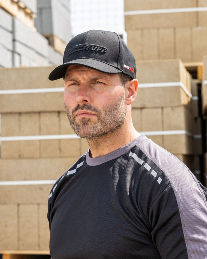 Black coloured TuffStuff Baseball Cap on construction background #colour_black