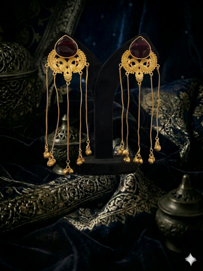 Pair of gold earrings with dark gemstones
