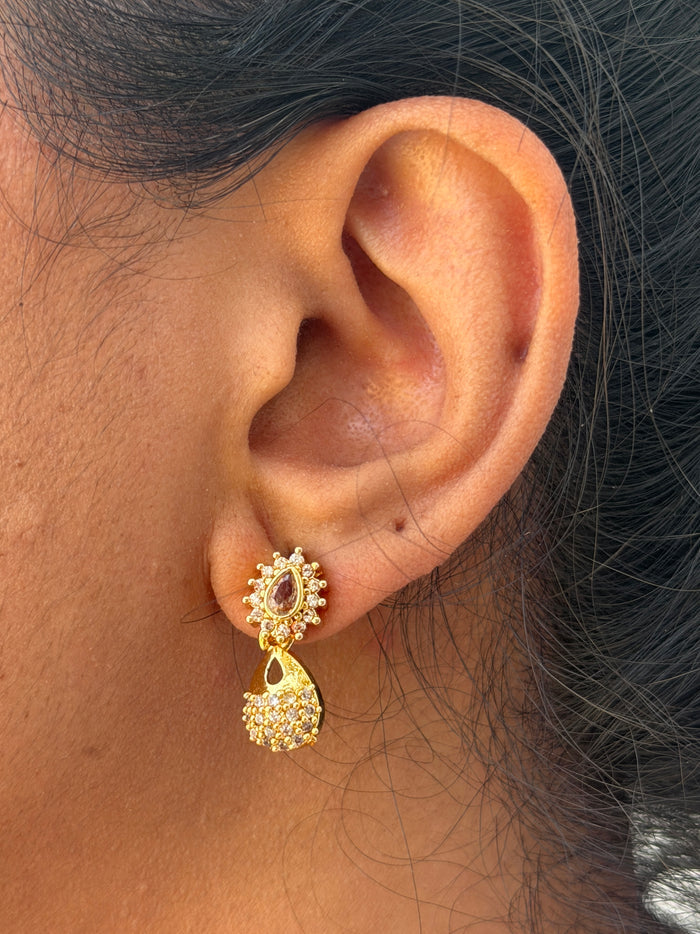 Gold earring with a red gemstone